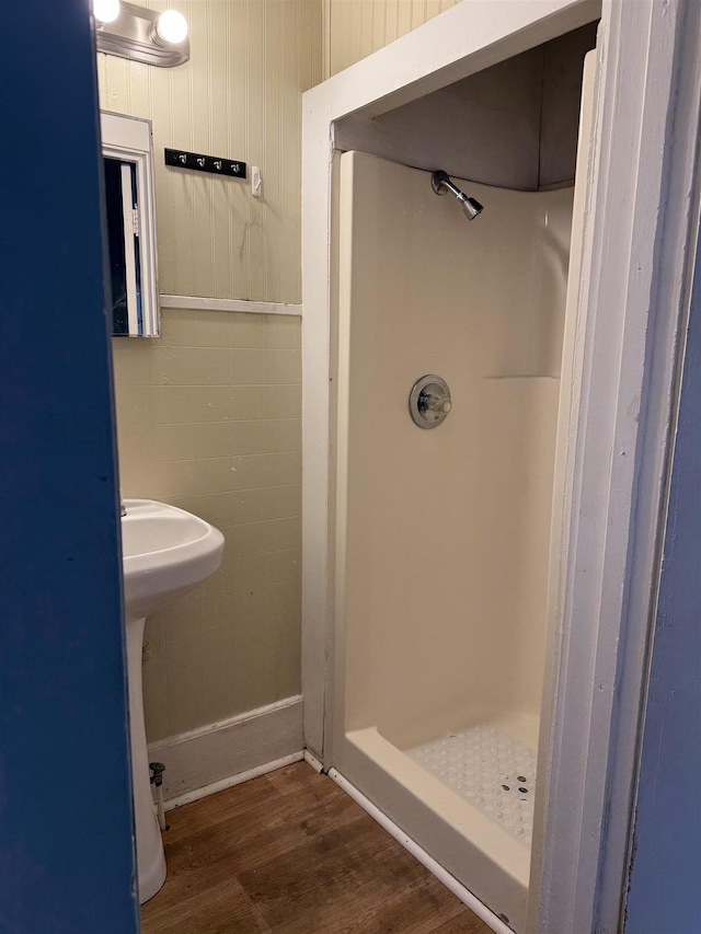 bathroom with sink, hardwood / wood-style flooring, and a shower