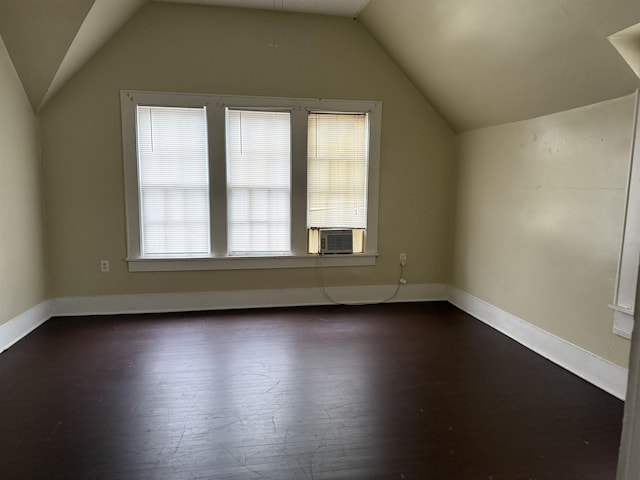 additional living space with dark wood-type flooring and vaulted ceiling