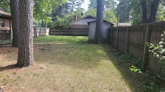 view of yard featuring an outdoor structure, a storage shed, and a fenced backyard