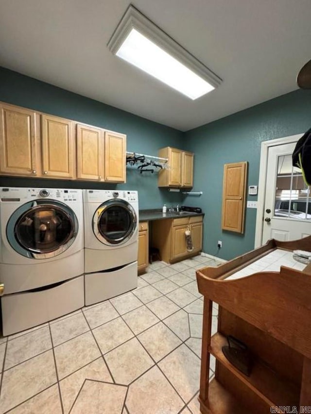 laundry room with light tile patterned flooring, washer and dryer, and cabinets