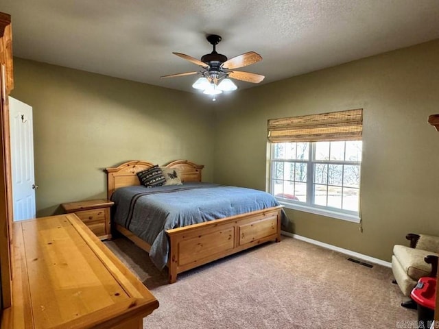 carpeted bedroom featuring a textured ceiling and ceiling fan