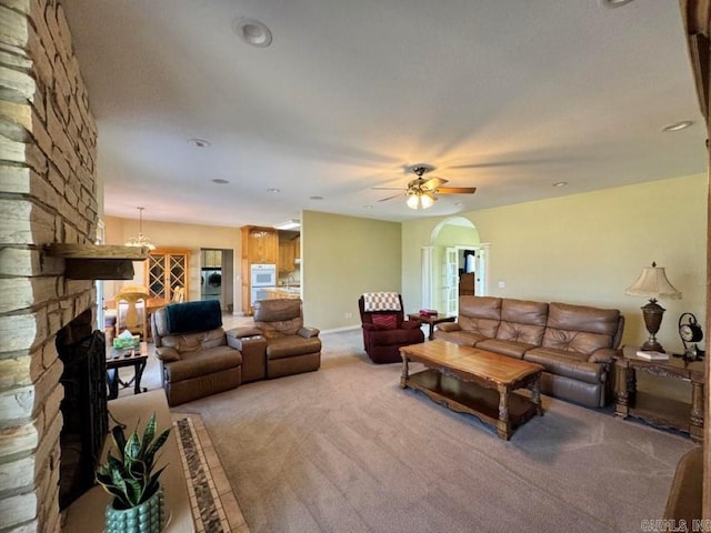 carpeted living room featuring ceiling fan, washer / clothes dryer, and a stone fireplace