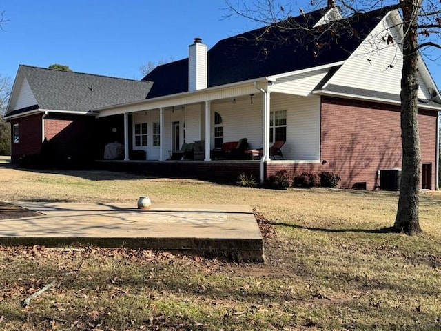 rear view of property with a yard, cooling unit, and a porch