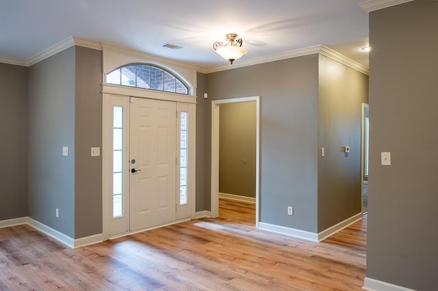 entrance foyer featuring ornamental molding and light hardwood / wood-style floors