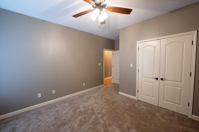 unfurnished bedroom with ceiling fan, carpet flooring, and a closet