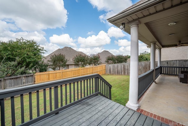 deck with a lawn and ceiling fan