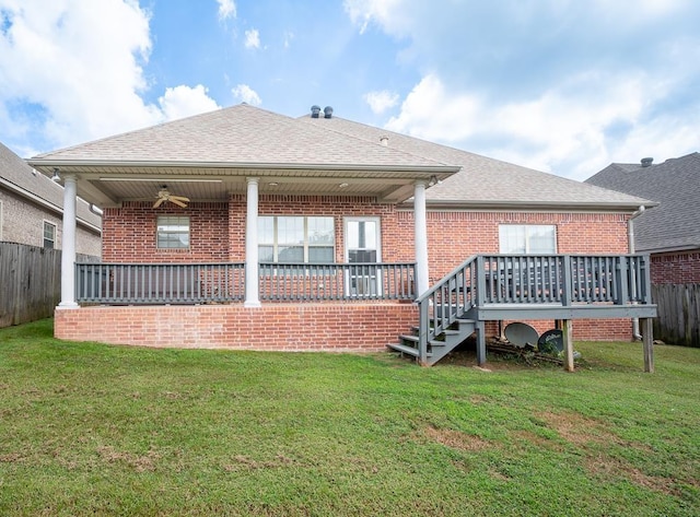 back of property with a yard and a deck