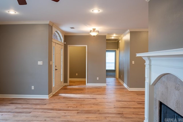 unfurnished living room with ceiling fan, light wood-type flooring, and crown molding