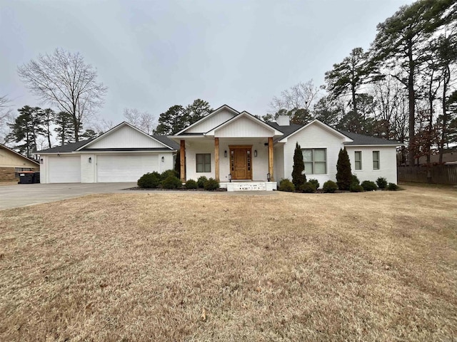 view of front of home with an attached garage, a chimney, concrete driveway, and a front yard