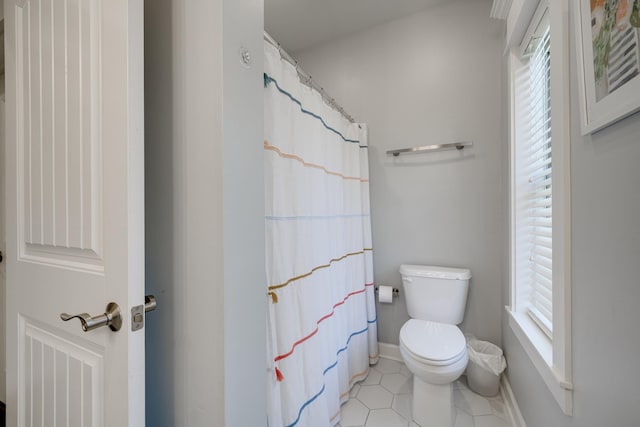 full bathroom featuring baseboards, toilet, and tile patterned floors