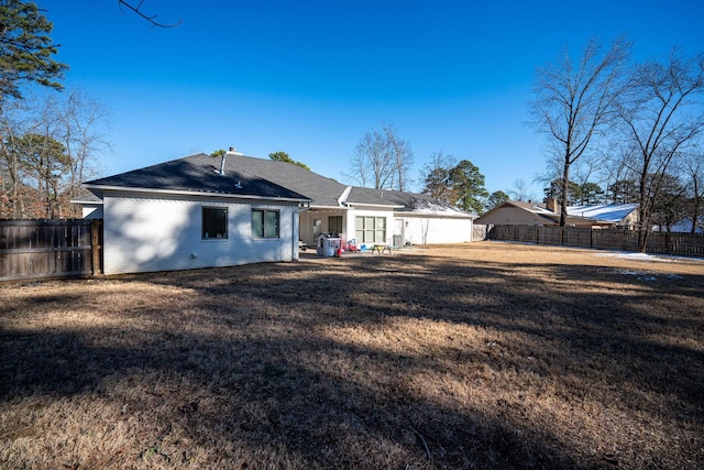 back of property featuring a yard, brick siding, a patio area, and a fenced backyard