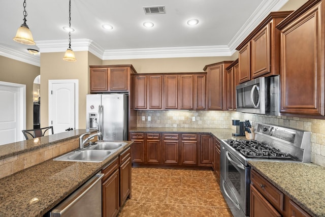 kitchen featuring dark stone countertops, appliances with stainless steel finishes, sink, and decorative light fixtures