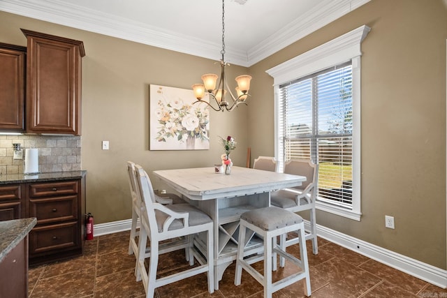 dining space with ornamental molding and a chandelier