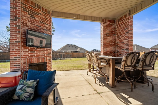 view of patio / terrace featuring an outdoor brick fireplace and exterior bar