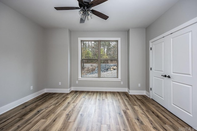 unfurnished bedroom featuring hardwood / wood-style floors and ceiling fan