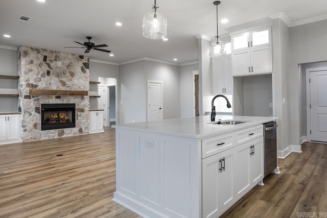 kitchen featuring wood-type flooring, pendant lighting, sink, white cabinetry, and a kitchen island with sink