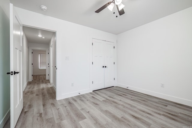 unfurnished bedroom featuring light hardwood / wood-style floors, a closet, and ceiling fan