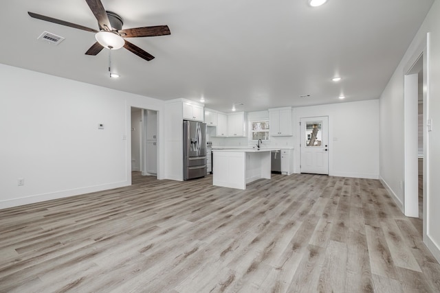 unfurnished living room with sink, ceiling fan, and light hardwood / wood-style floors