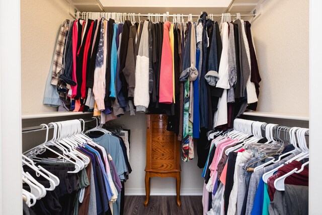 spacious closet with dark hardwood / wood-style flooring