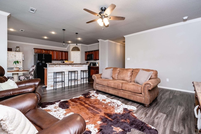 living room with a textured ceiling, ceiling fan, dark hardwood / wood-style floors, and ornamental molding