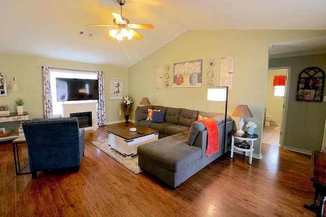 living room featuring ceiling fan, lofted ceiling, and dark wood-type flooring