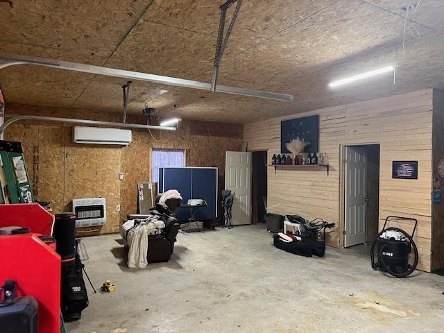 garage with a wall mounted AC, heating unit, and wooden walls