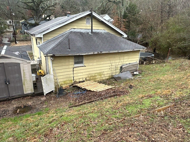 rear view of house with a storage shed