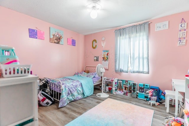 bedroom with a textured ceiling and hardwood / wood-style floors