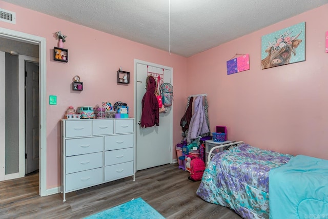 bedroom with dark wood-type flooring and a textured ceiling