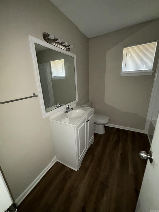 bathroom with toilet, vanity, and wood-type flooring