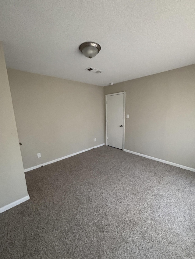 carpeted spare room with a textured ceiling