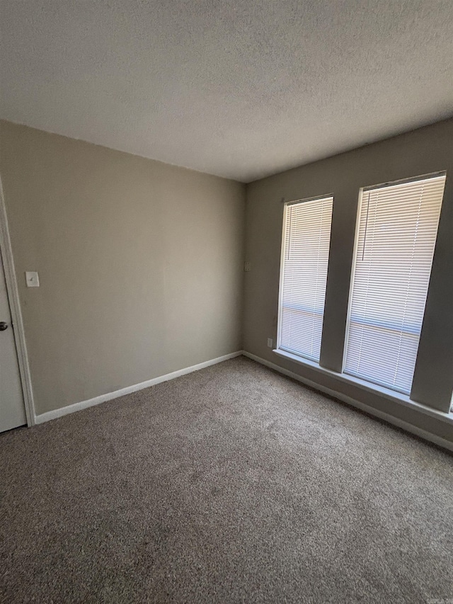 carpeted spare room featuring a textured ceiling