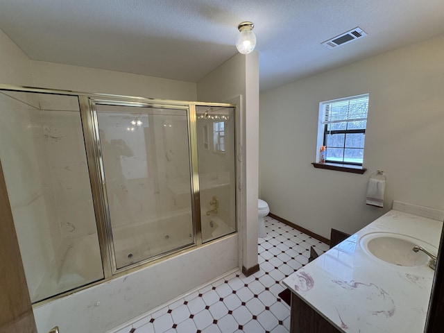 full bathroom with bath / shower combo with glass door, vanity, toilet, and a textured ceiling