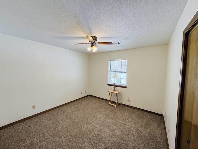 carpeted spare room with ceiling fan and a textured ceiling