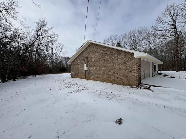 snow covered property with a garage