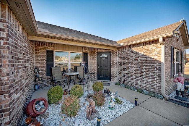 view of exterior entry with a patio area