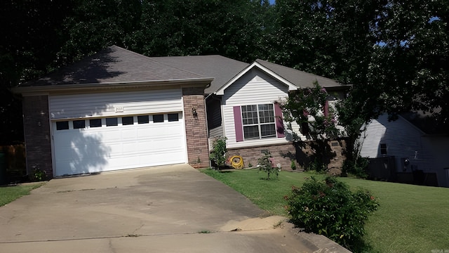 ranch-style house with an attached garage, concrete driveway, brick siding, and a front yard