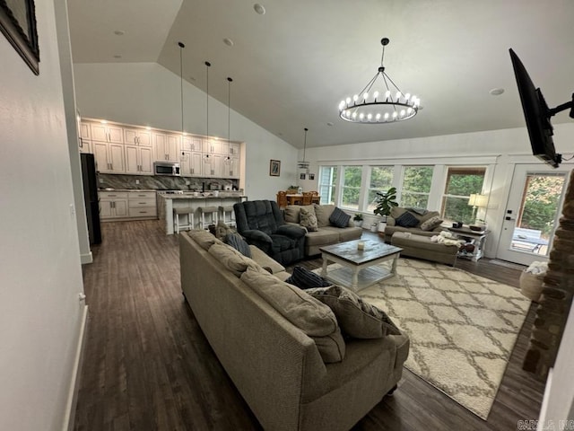 living room with a chandelier, high vaulted ceiling, and wood finished floors