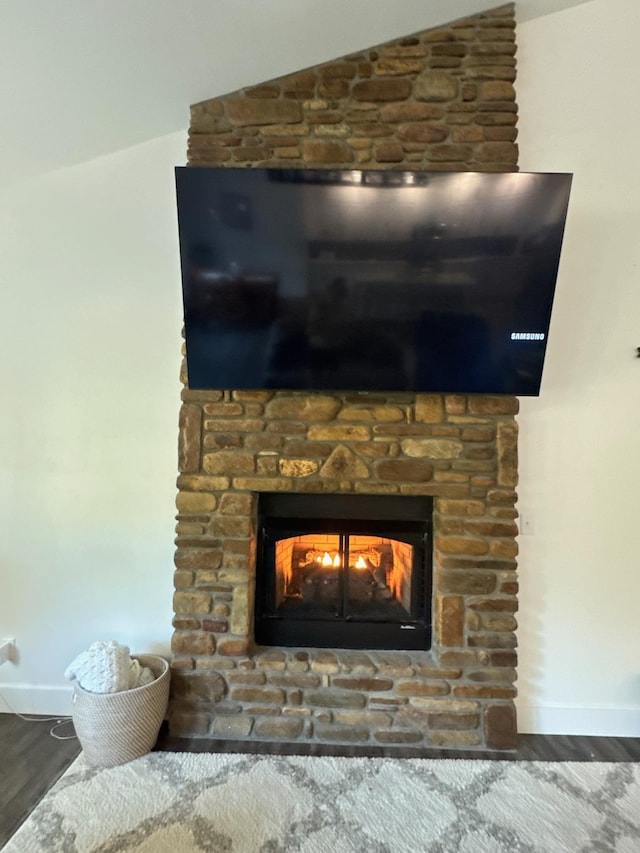 room details with a fireplace, baseboards, and wood finished floors