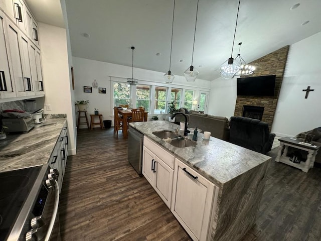 kitchen featuring stainless steel appliances, a sink, light stone counters, and an island with sink