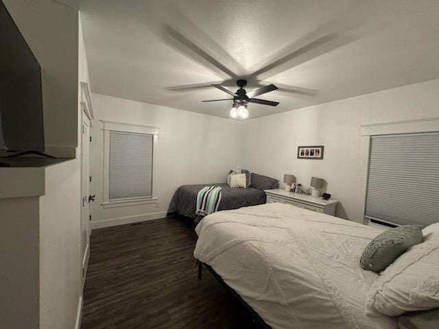 bedroom featuring a ceiling fan, dark wood-style flooring, and baseboards