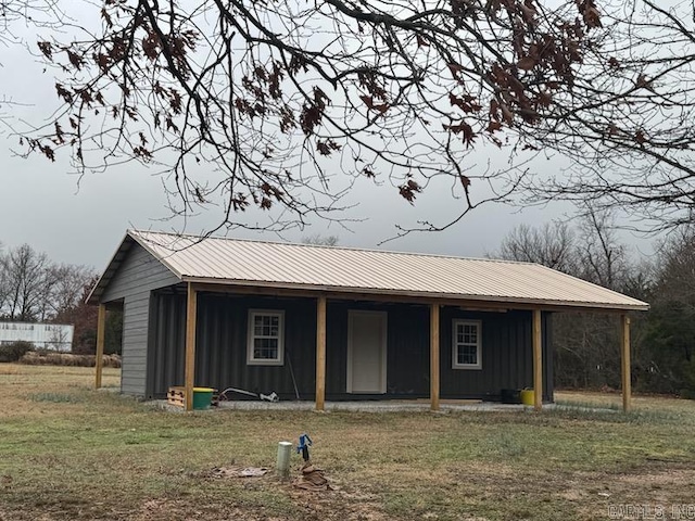 view of front of property with a front lawn, metal roof, and board and batten siding