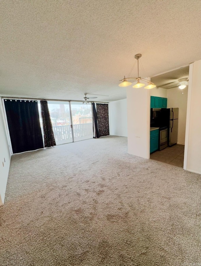 carpeted spare room featuring ceiling fan and a textured ceiling