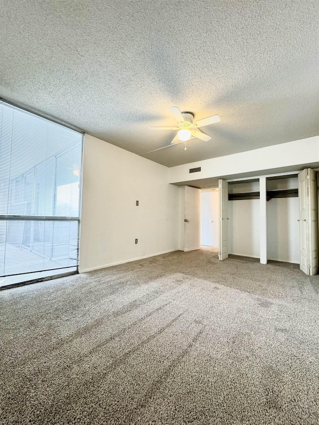 unfurnished bedroom with carpet, ceiling fan, and a textured ceiling