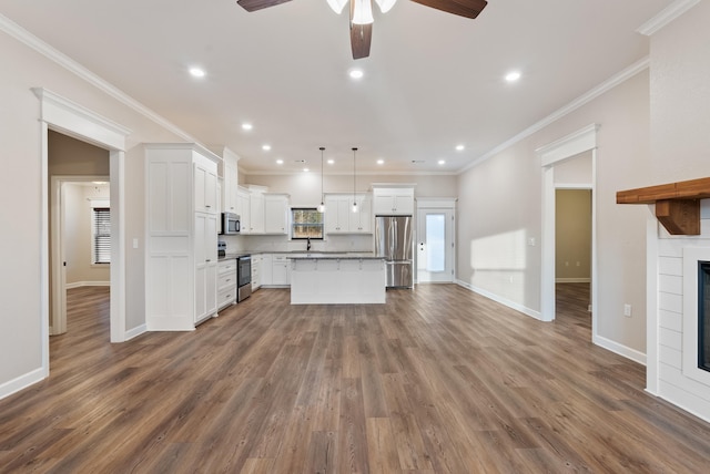 unfurnished living room featuring ceiling fan, sink, dark wood-type flooring, and crown molding