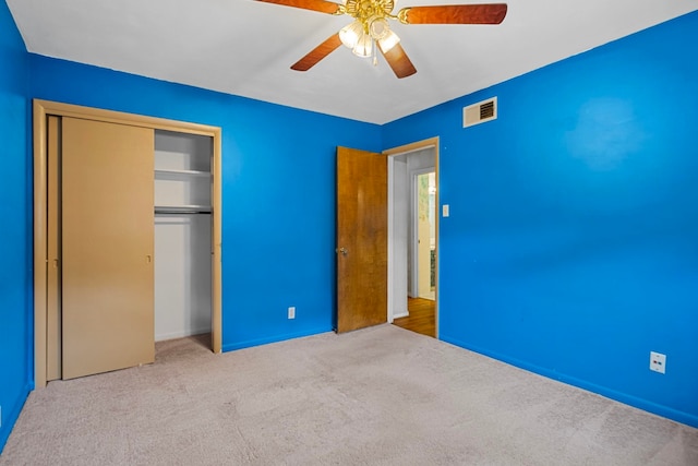 unfurnished bedroom featuring a closet, ceiling fan, and light colored carpet