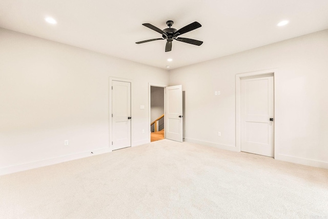 empty room with light colored carpet, ceiling fan, recessed lighting, and baseboards