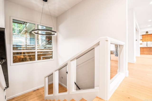 staircase featuring baseboards, a towering ceiling, and wood finished floors