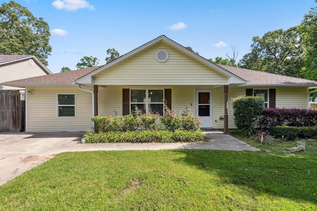 ranch-style home with covered porch, roof with shingles, and a front yard