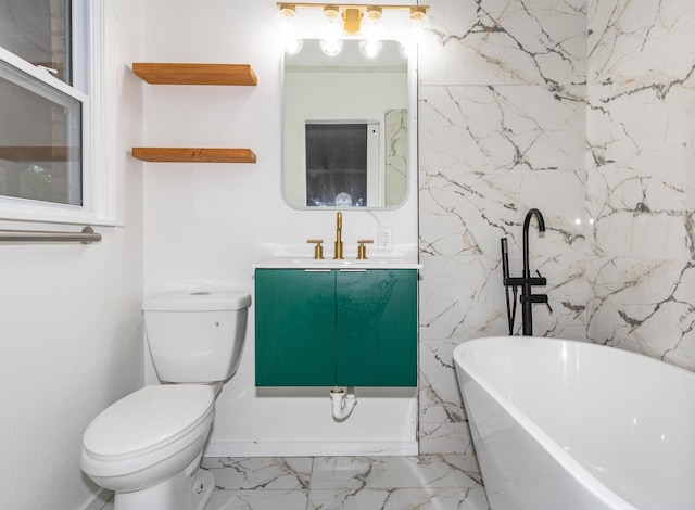 full bathroom featuring toilet, marble finish floor, a freestanding bath, and vanity